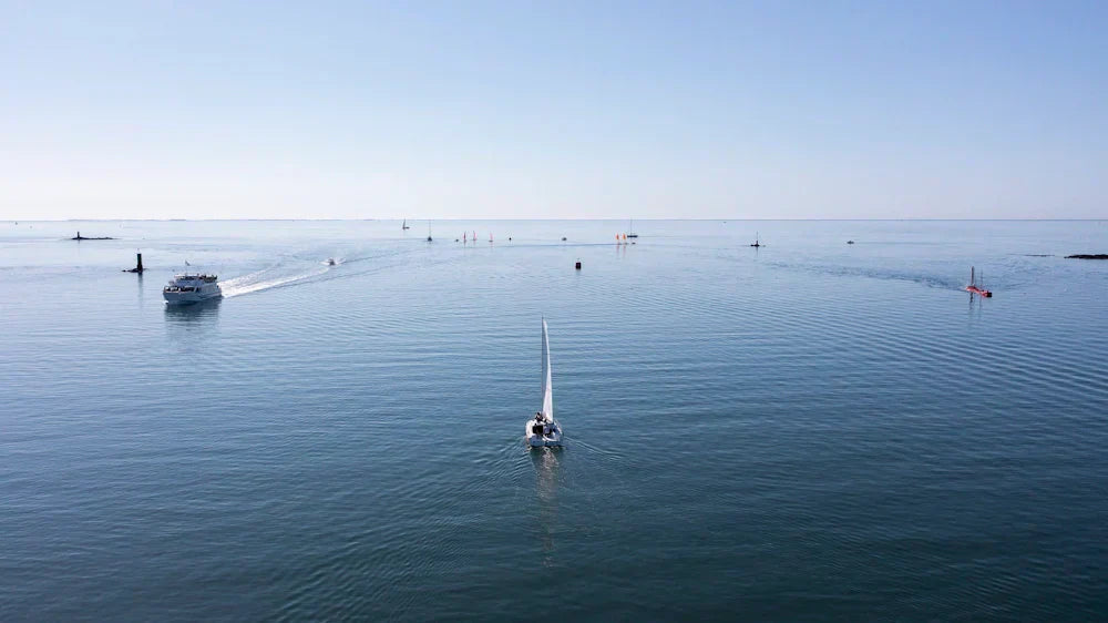 Blue horizon, with a sailboat in the center