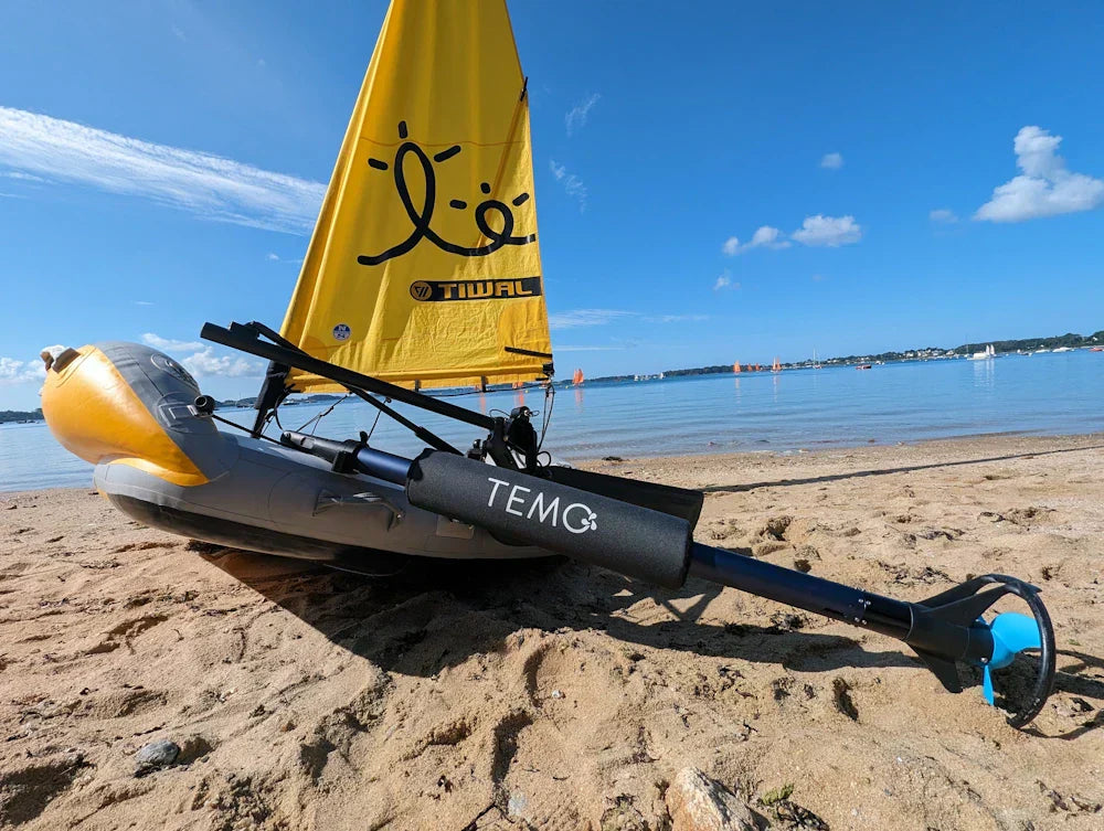 Inflatable Tiwal sailboat on the sand with the TEMO·450 mounted on its bracket and its buoyancy kit
