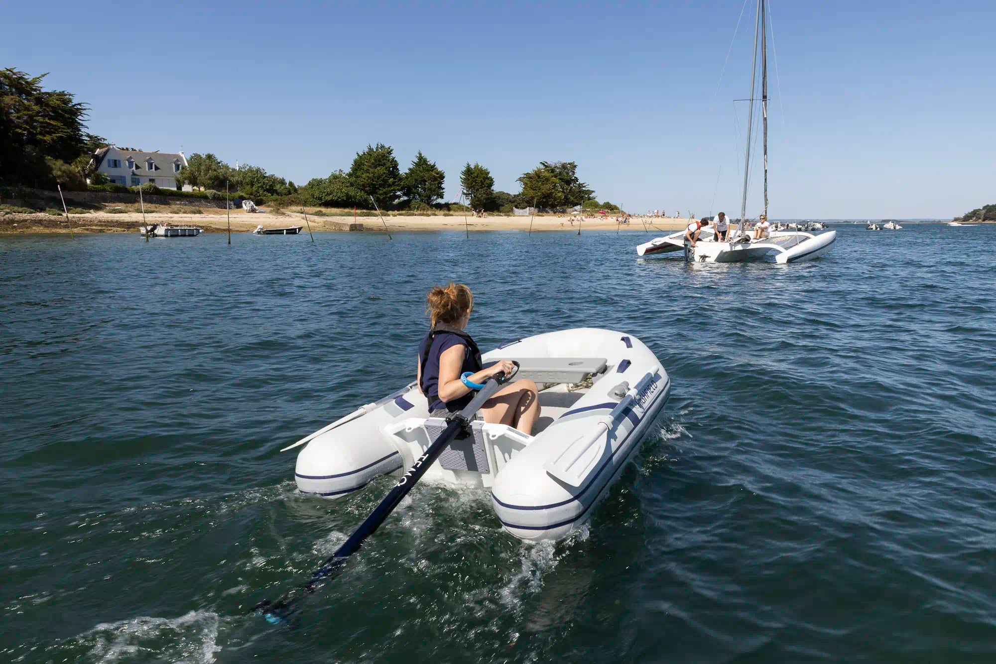 Annexe propulsé pour un moteur hors-bord TEMO·450 allant vers un trimaran au mouillage